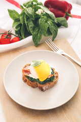 Tasty sandwich with florentine egg on table