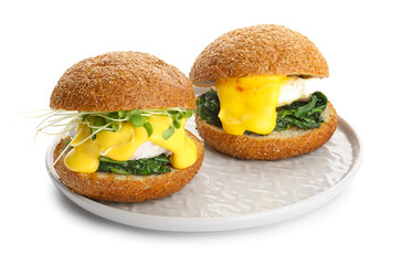 Plate of tasty burgers with florentine eggs on white background