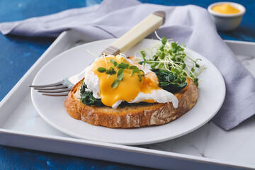 Plate with tasty sandwich and florentine egg on color  background, closeup