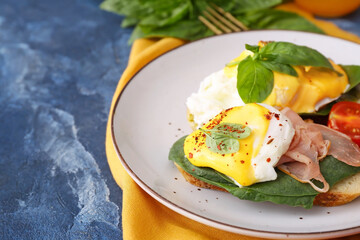 Tasty sandwiches with florentine eggs and bacon on color background, closeup