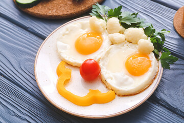 Creative breakfast for children with eggs and fresh vegetables on wooden background, closeup