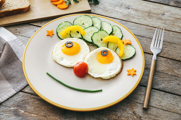 Creative breakfast for children with eggs and fresh vegetables on wooden background, closeup