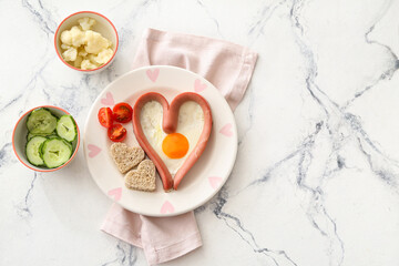 Creative breakfast for children with egg, sausage and fresh vegetables on light background