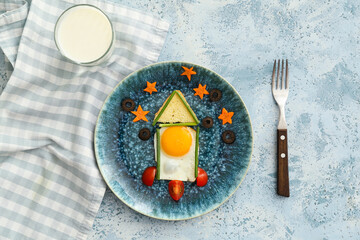 Creative breakfast for children with egg and fresh vegetables on color background