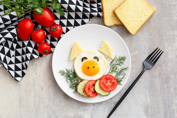 Creative breakfast for children with egg and fresh vegetables on light background