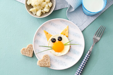 Creative breakfast for children with egg and milk on color background