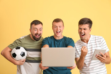 Happy men after winning of their sports bet on color background