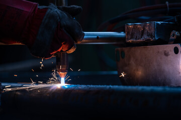 Plasma cutting of the pipe. the operator cuts with a plasma torch