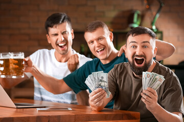 Happy men after winning of their sports bet in pub