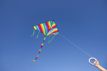 Girl flying kite in blue sky