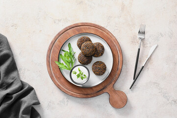 Obraz na płótnie Canvas Plate with tasty falafel balls and sauce on light background