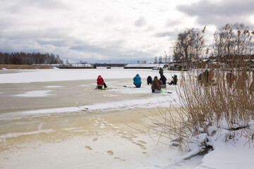 City Riga, Latvia. Frozen river and anglers fishing fish.