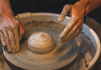 Potter's wheel. Working with clay. Potter's hands.
