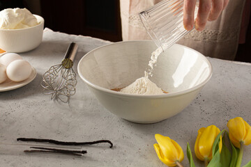 Woman adding flour into the bowl Basque cheesecake burned cheesecake