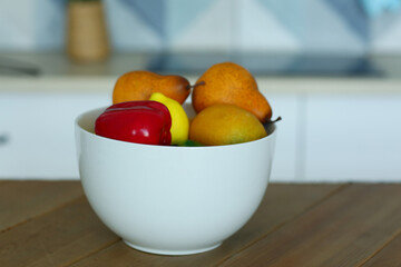 fruit in bowl still life on the table closeup photo on blue kitchen background