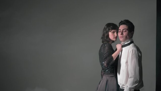 Young man and woman stand very close to each other and look in different directions. The concept of relations between the sexes. A couple in love in which a woman tries to dominate.