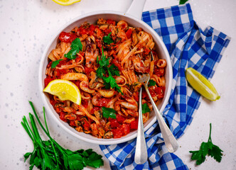 Italian seafood pasta in a white frying pan.top view