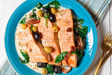 Salmon stew with cream sauce on a plate, top view