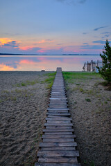 Fototapeta premium wooden path to the lake at sunset