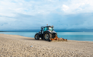 Beach on Rugen Island, Germany. Tractor grooming  sand on the beach at Baltic Sea