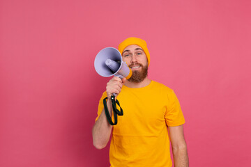 Attention! European man shouting in megaphone on pink background