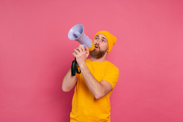 Attention! European man shouting in megaphone on pink background