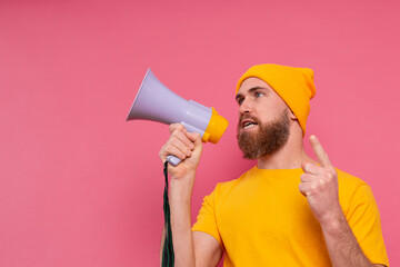 Attention! European man shouting in megaphone on pink background