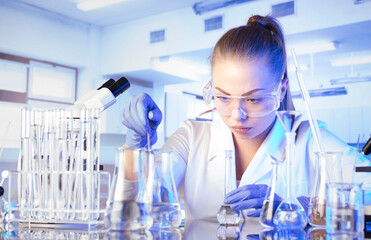 Fototapeta premium Laboratory concept background. Young scientist during experiment and using microscope in modern laboratory.