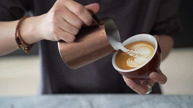 Barista pouring Swan Latte art in coffee cups at cafe
