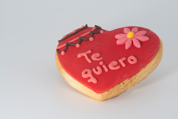 Deliciosa galleta glaseada de color rojo con una peque&ntilde;as flor rosa y las palabras "te quiero".  Un bonito regalo para San Valent&iacute;n.