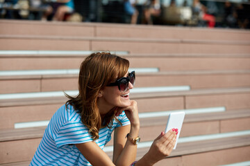 Young woman using modern smartphone outdoors.