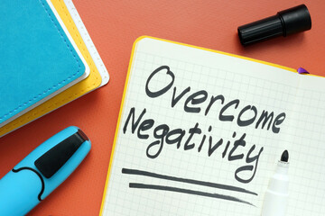 Overcome negativity handwritten memo on the page and marker.