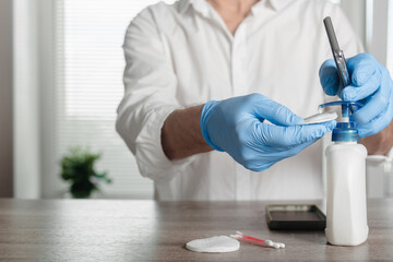 Closeup photo of man using antibacterial soap to disinfect phones from bacteria, personal device sanitization reminder