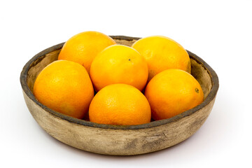 oranges in a clay bowl on white background