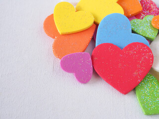 A pile of colorful hearts on a white background. The concept Valentine's Day, anniversary, and wedding. Close up with copy space for text.
