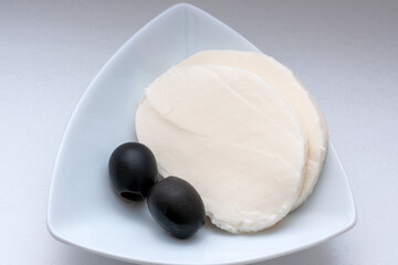 Two pieces of soft cheese