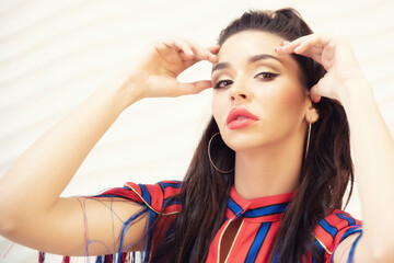 Fototapeta premium Fashion portrait of brunette girl wearing red and blue dress