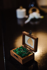 Two gold wedding rings in a beautiful wooden casket with green moss. Wedding accessories. Bride morning