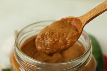 Jar and wooden spoon with squash caviar, close up