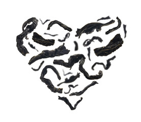 Gedroogde zwarte thee close-up in de vorm van een hart op witte achtergrond