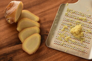 Fresh grated ginger on wooden board.