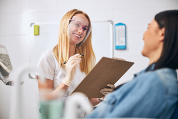 Positive delighted dentist communicating with her patient