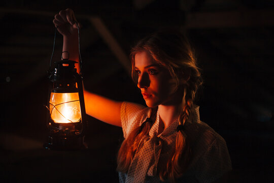 a girl with an antique lantern near her face