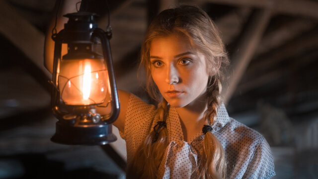 a girl with an antique lantern near her face
