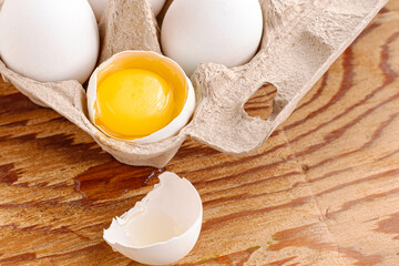 the broken egg with the yolk inside lies in the stand along with the whole eggs
