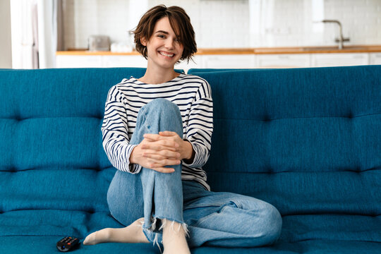 Happy beautiful woman smiling while sitting on couch