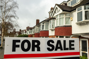 Obraz premium Estate agent For Sale sign on street of houses