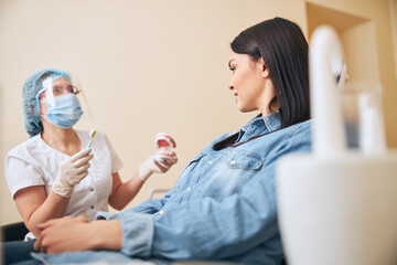 Fototapeta premium Young brunette woman listening to her family stomatologist