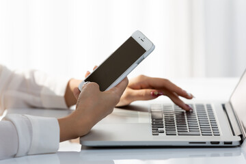 スマートフォン・ノートパソコンに入力する女性