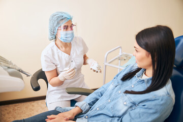 Attentive brunette female listening to her stomatologist